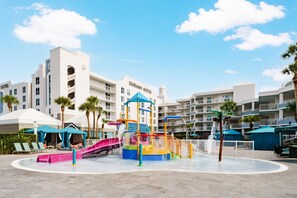 A water park with slides and a play structure, surrounded by hotel buildings with balconies. - Embassy Suites by Hilton Orlando Lake Buena Vista Resort (Orlando)