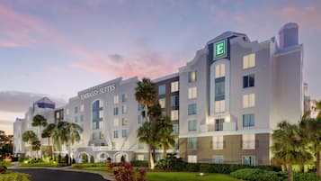 Un hôtel à plusieurs étages, reconnaissable à son grand panneau « Embassy Suites », à son logo en forme de « E » et à son jardin bien entretenu, agrémenté de palmiers.