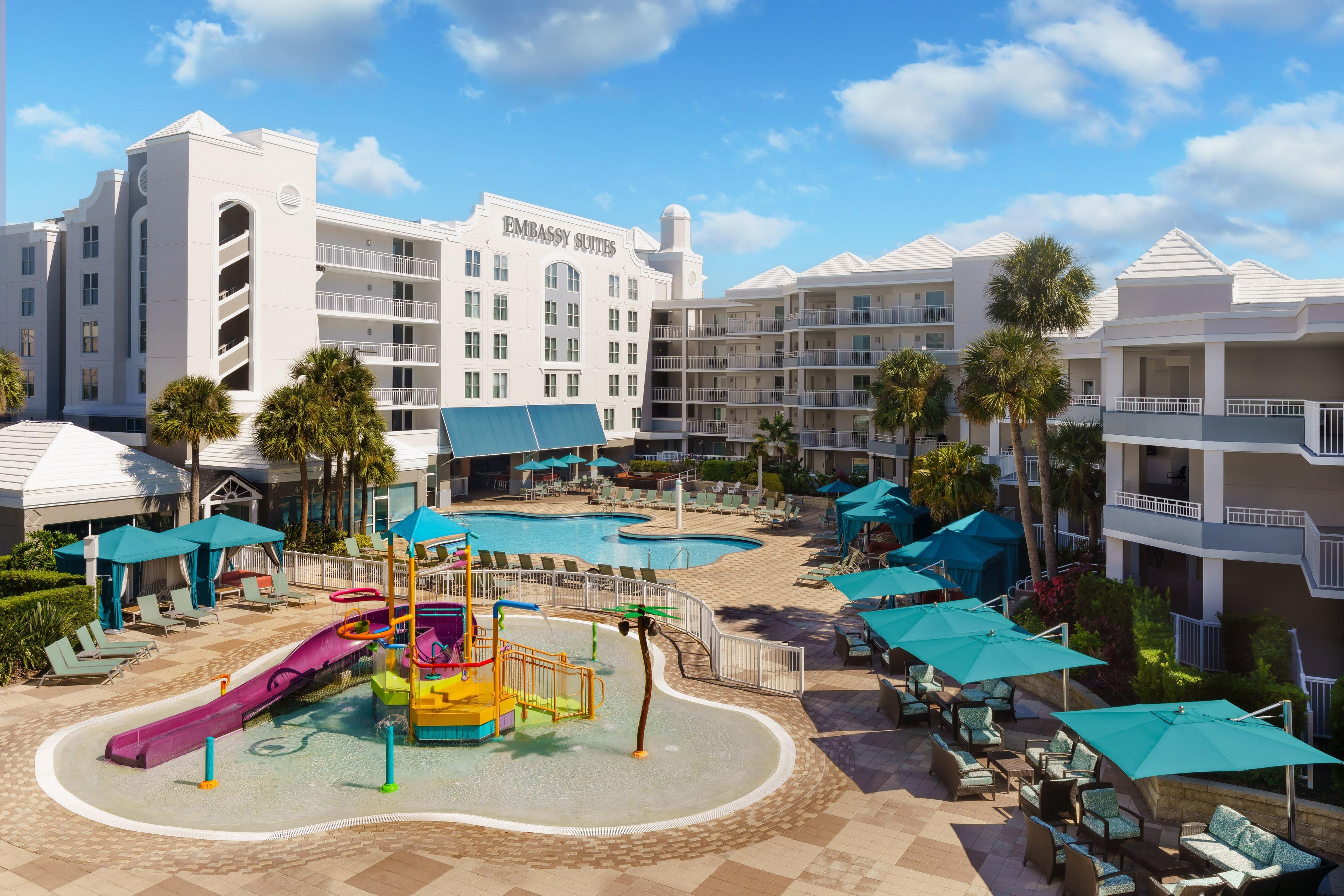 Hotel com área de piscina, incluindo escorrega e espreguiçadeiras.