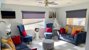 A modern living room with two sofas, a coffee table, and a ceiling fan.