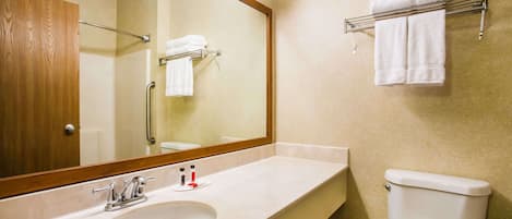 A bathroom with a sink, mirror, towel rack, and toilet.