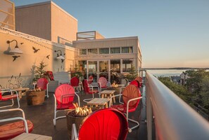 Relax on the outdoor terrace with a fire pit, surrounded by potted plants and comfortable seating.