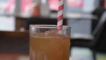 A tall glass with a striped straw on a wooden table.