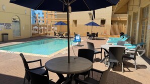 A poolside area with a pool, lounge chairs, and umbrellas. - Days Inn by Wyndham Georgetown (Georgetown)