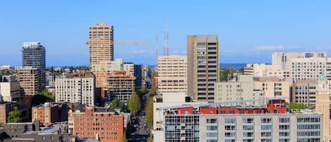 A cityscape with various buildings, including high-rises and mid-rise structures, under a clear sky.