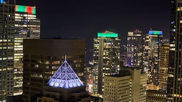 A nighttime cityscape with illuminated buildings and a prominent pyramid-shaped structure in the foreground.