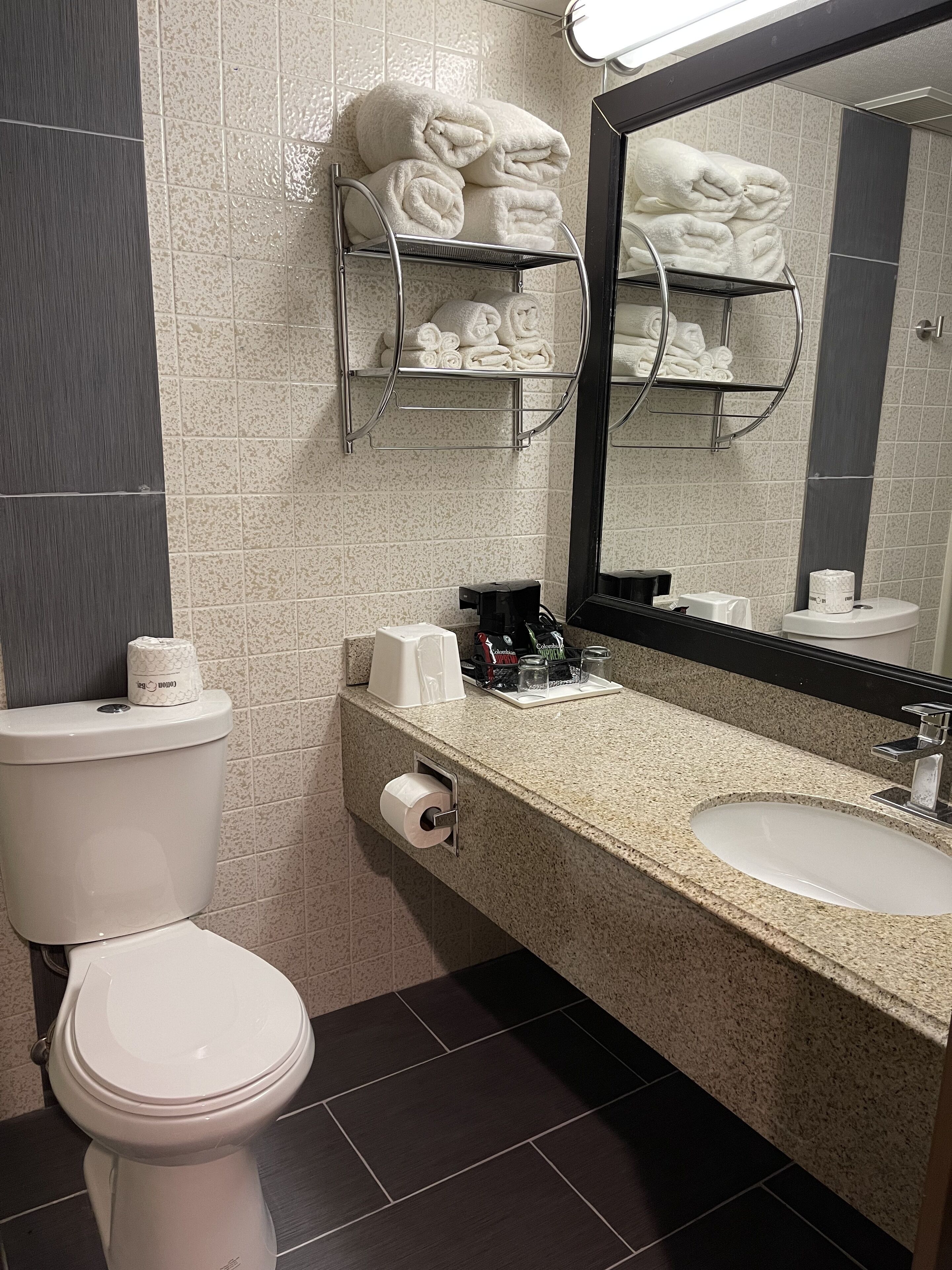 A modern bathroom with a toilet, sink, and towel rack.