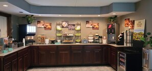 A breakfast bar with various food items and a coffee station.