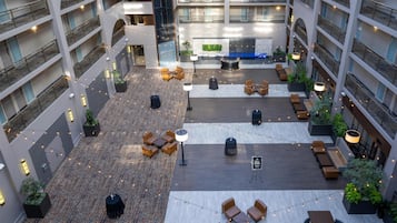 A multi-level atrium with seating areas, a central water feature, and string lights.