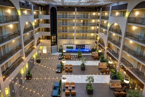 A multi-level hotel atrium with balconies, seating areas, and a central water feature. - Embassy Suites by Hilton Seattle Bellevue (Bellevue)