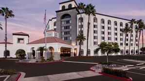 A Courtyard by Marriott hotel with a central courtyard, palm trees, and a fountain. - Courtyard by Marriott San Diego Miramar (San Diego)