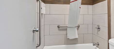 Un baño con bañera, inodoro y zona de ducha.