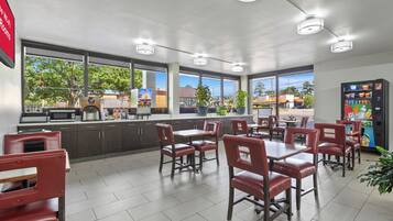 A cafe with a counter, seating area, and vending machine.