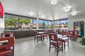 Un café avec un comptoir, un espace pour s’asseoir et un distributeur automatique.