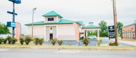 A Country Garden & Suites hotel with a green roof, a parking lot, and a sign indicating entrance through Mach 1.