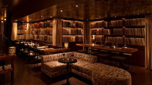 A cozy library with bookshelves, a sofa, and a bar area. - The Phoenix Hotel (San Francisco)