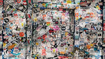 A wall covered with various stickers and posters.