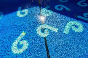 A pool with mosaic tiles and a central light fixture. - The Phoenix Hotel (San Francisco)