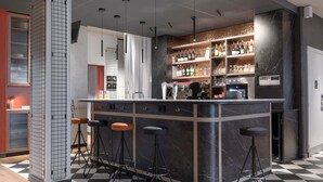 A modern bar area with a checkered floor, bar stools, a counter with a beverage dispenser, and a wine rack. - ibis Rueil-Malmaison Centre (Rueil-Malmaison)