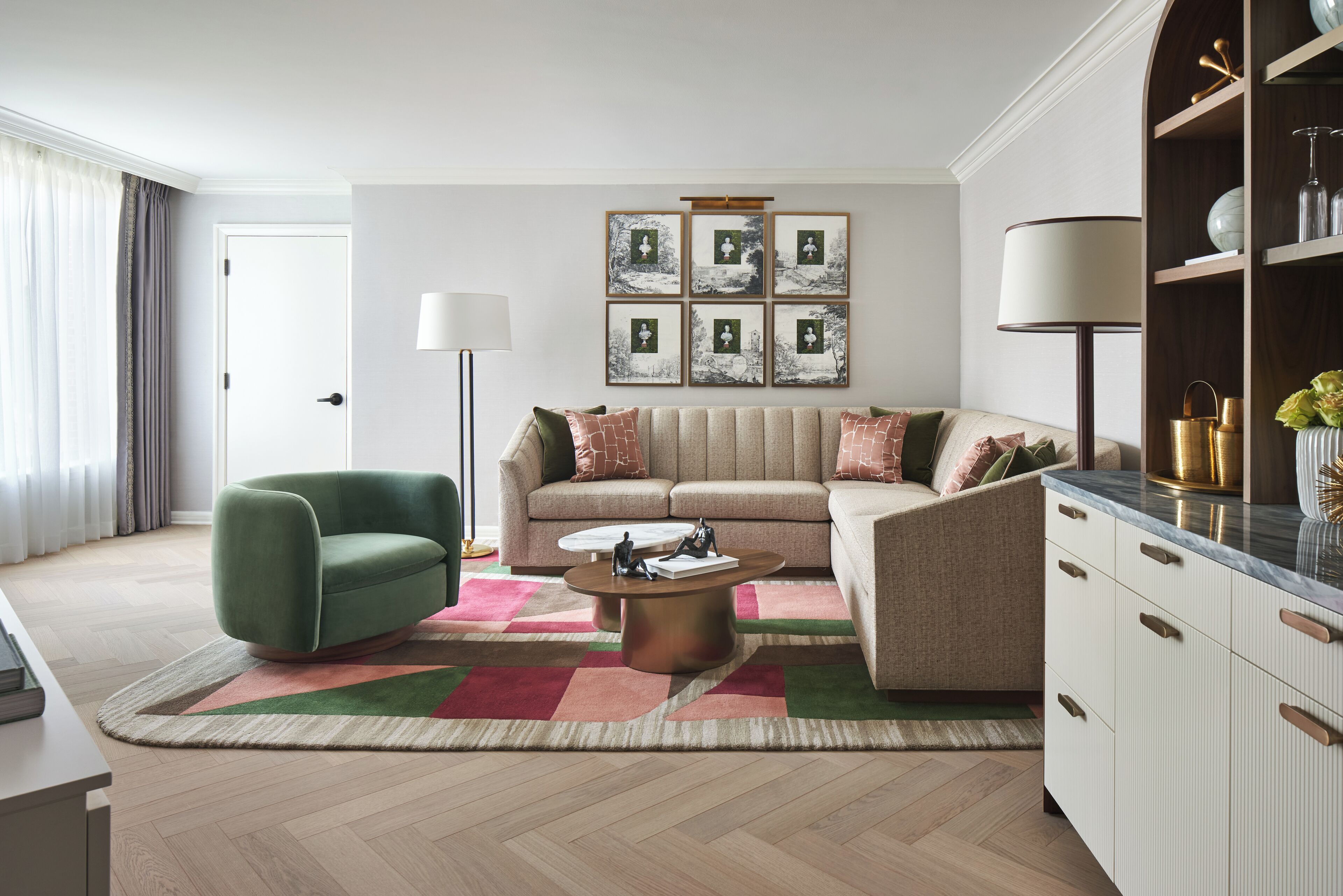 A modern living room with a sofa, a green armchair, a coffee table, and a bookshelf.