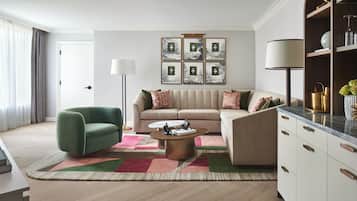 A modern living room with a sofa, a green armchair, a coffee table, and a bookshelf.