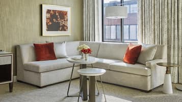 Ein modernes Wohnzimmer mit einem Ecksofa, einem runden Couchtisch und einer Stehlampe.