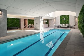 Relax by the rectangular pool surrounded by lounge chairs and a seating area.