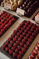 Una exhibición de bombones variados, organizados en filas.