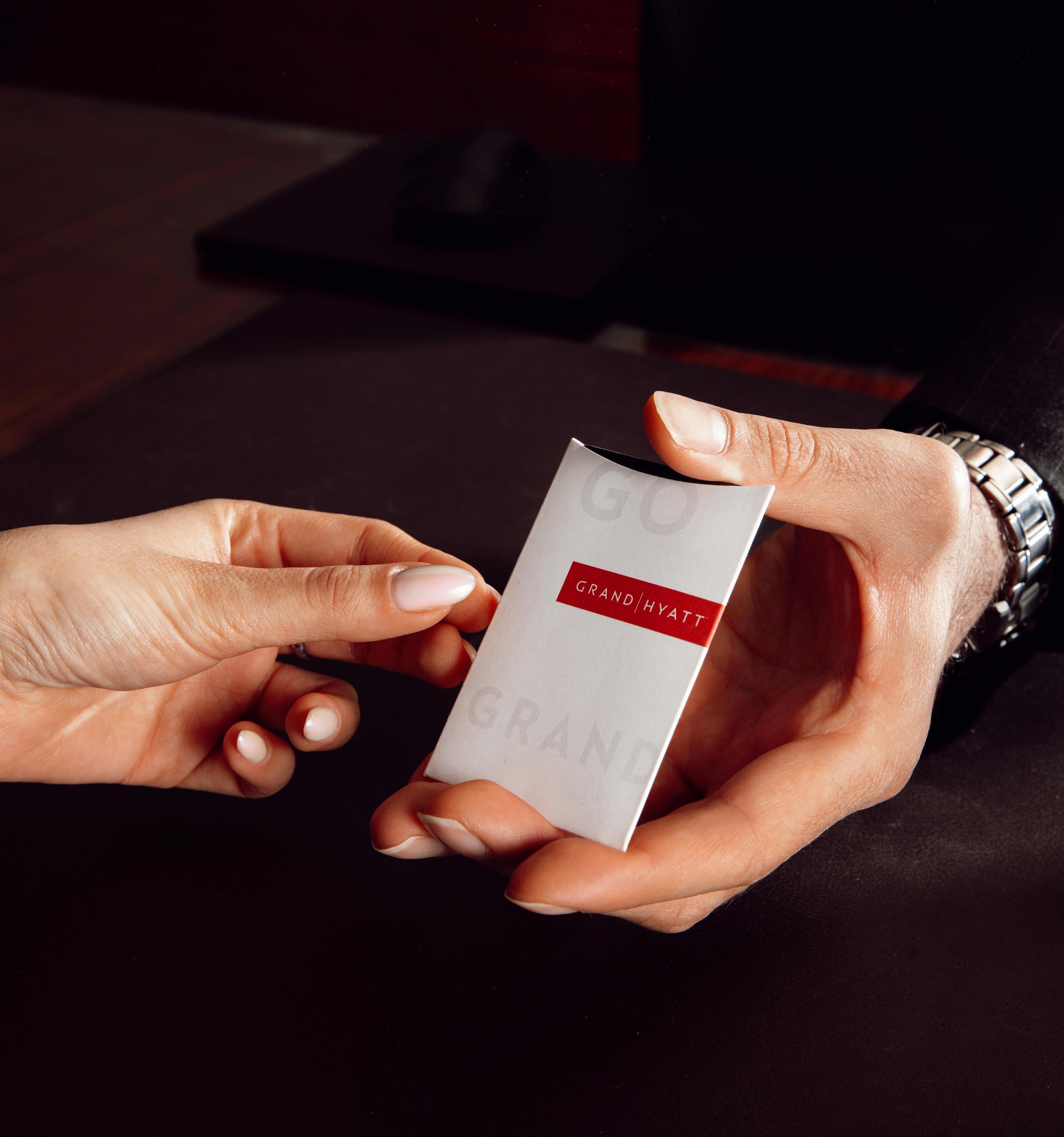 Una mano sosteniendo una tarjeta con la leyenda 'GRAND HYATT'.