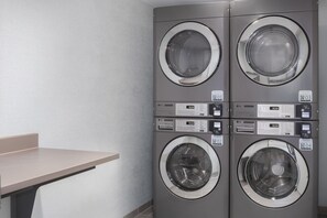 A four-washer laundry facility with direct drive controls and QR codes for payment. - DoubleTree by Hilton Wilmington, NC (Wilmington)