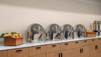 A buffet setup with food items and beverage dispensers.