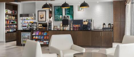 Eine moderne Bar mit Sitzgelegenheiten, einer Kaffeemaschine und einer Speisekarte.