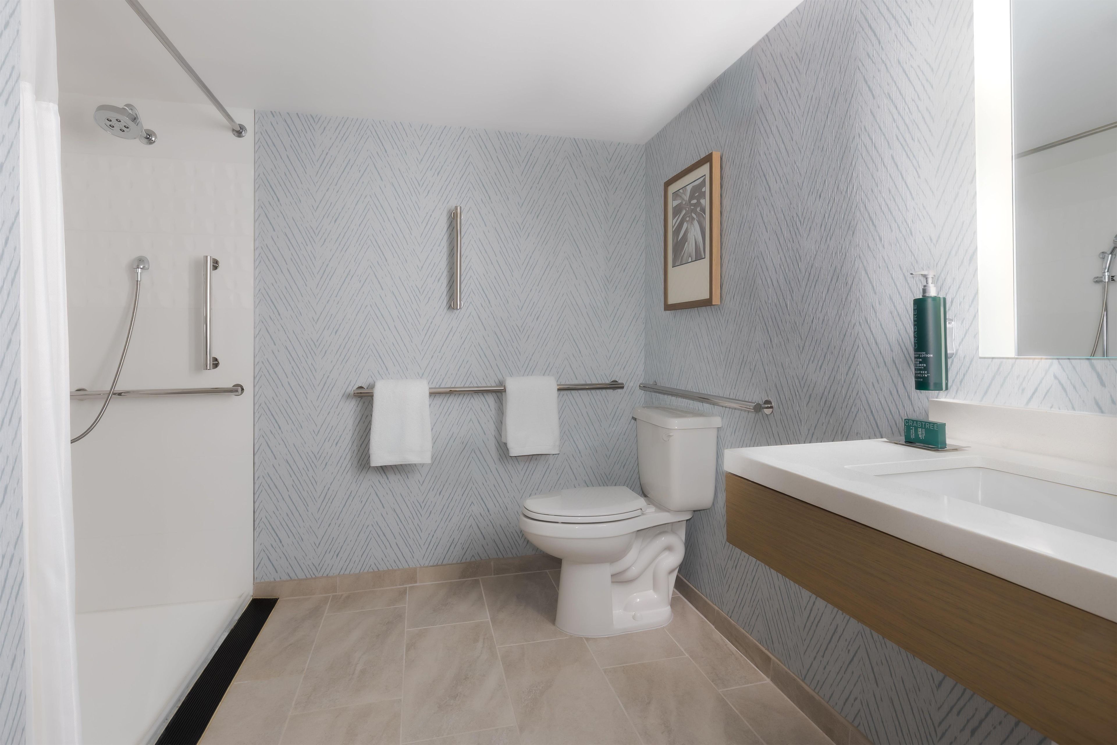 Une salle de bain moderne équipée d’une douche, de toilettes et d’un lavabo.