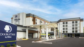 A DoubleTree by Hilton hotel with a modern design, a covered entrance, and a parking lot.