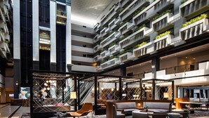 A modern hotel lobby with a central seating area, multiple floors with balconies, and a large staircase. - Hyatt Regency Savannah (Savannah)