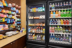 Un présentoir réfrigéré contenant une variété de boissons et d’en-cas.