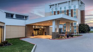 A DoubleTree by Hilton hotel with a modern design, a covered entrance, and a landscaped driveway. - DoubleTree by Hilton Cincinnati Airport (Florence)