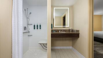 Un bagno d'albergo con doccia, WC, lavabo e specchio.
