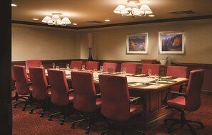 A conference room with a long table, red chairs, and two framed pictures on the wall. - DoubleTree by Hilton Cincinnati Airport (Florence)