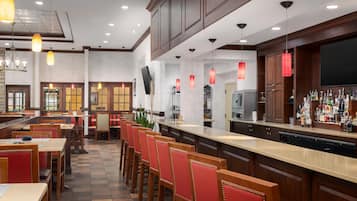 A restaurant with a bar area, multiple seating options including booths and tables, and a variety of lighting fixtures.