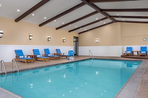 Una piscina techada, sillones reclinables de piscina