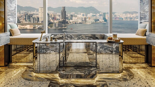A luxurious room with a large window offering a cityscape view, a marble-tiled floor, and a central seating area with a coffee table. - Island Shangri-La, Hong Kong (Hong Kong)