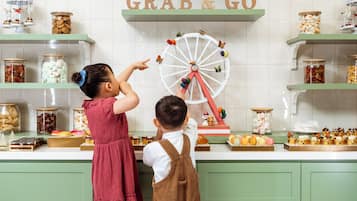 Una cocina con un cartel que dice 'Grab & Go', una noria y varios alimentos en estantes.