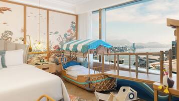 Une chambre d’enfant avec un lit superposé, un petit espace de jeu sur le thème d’un bateau et une vue sur la ville.