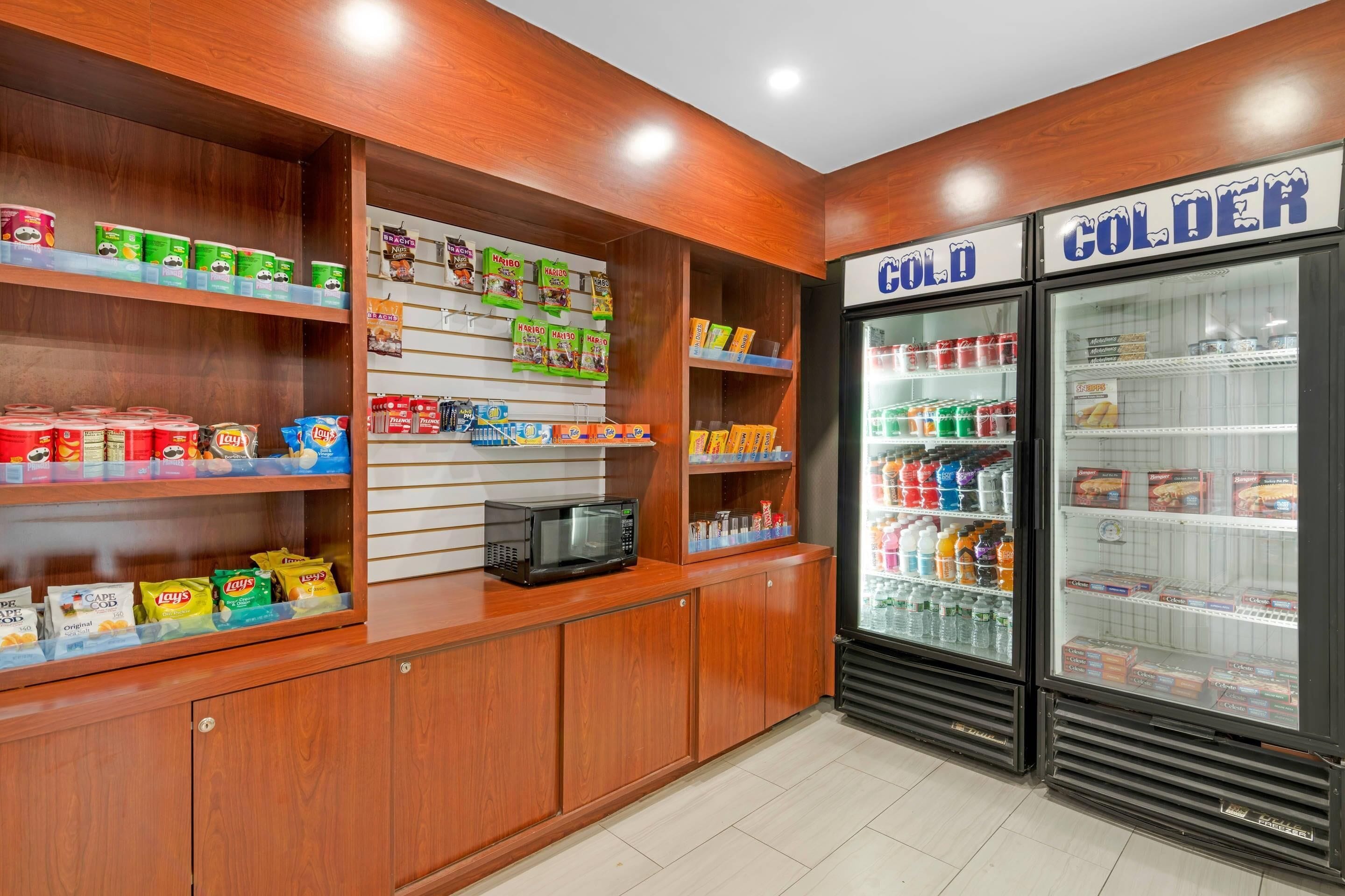 A snack and cold drink section with shelves stocked with various snacks and a refrigerator labeled "COLD" and "COLDER".