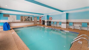 An indoor swimming pool with clear blue water, a lifebuoy, and a few lounge chairs. - Keene Elm City Hotel, an Ascend Collection Hotel (Keene)