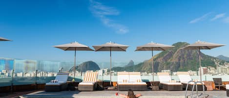 Piscine extérieure, parasols de plage, chaises longues