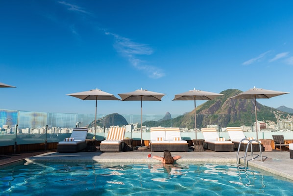 Piscine extérieure, parasols de plage, chaises longues