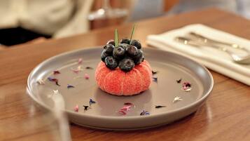 Un postre en un plato con cuchara y servilleta sobre una mesa.