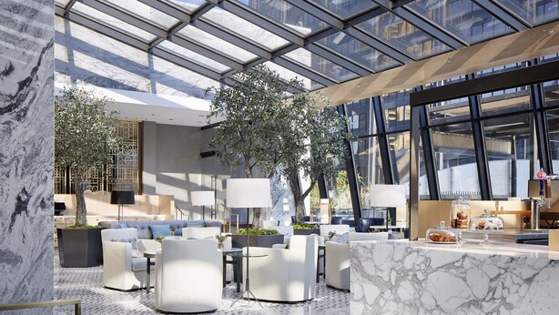 A modern indoor space with a glass ceiling, marble flooring, and contemporary furniture.